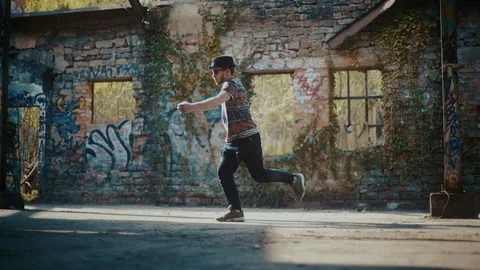 Man dancing in abandoned building with graffiti on wall Stock Footage 117917351