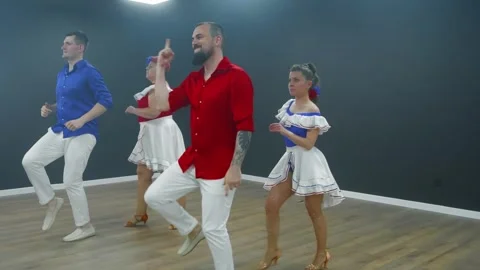Man dancing bachata in red shirt, white pants against studio background Stock Footage 337216725