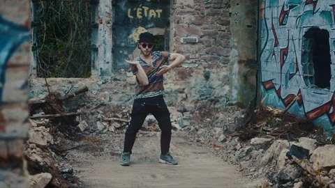 Man dancing in between rubble in abandoned building Stock Footage 117916521