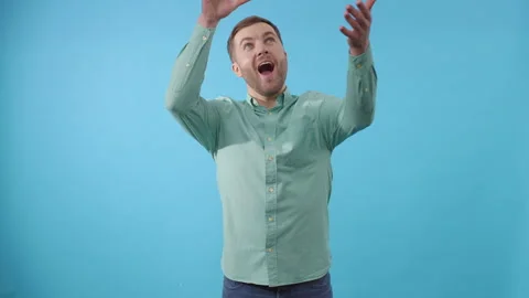 Man dancing with bunch of flowers on blue background Video stock 266457710