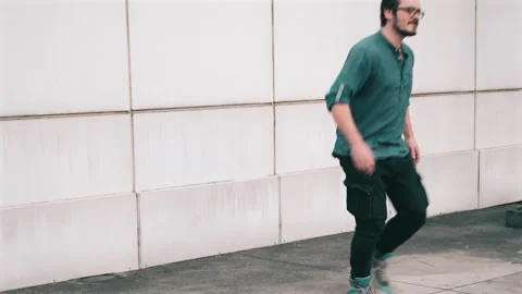 Man dancing electro-twist at city wall background. Happy dancer enjoying his Stock Footage 273775226