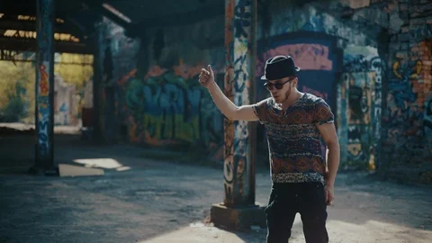 Man dancing in empty building and looking straight at camera 스톡 동영상 117917312