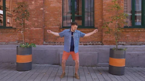 Man dancing with a good mood to the camera in an office district during a break Video stock 139011481