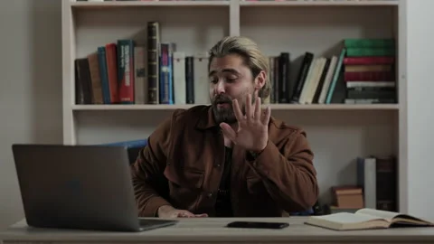 Man dancing with hands while sitting at desk with laptop 動画素材 172525894