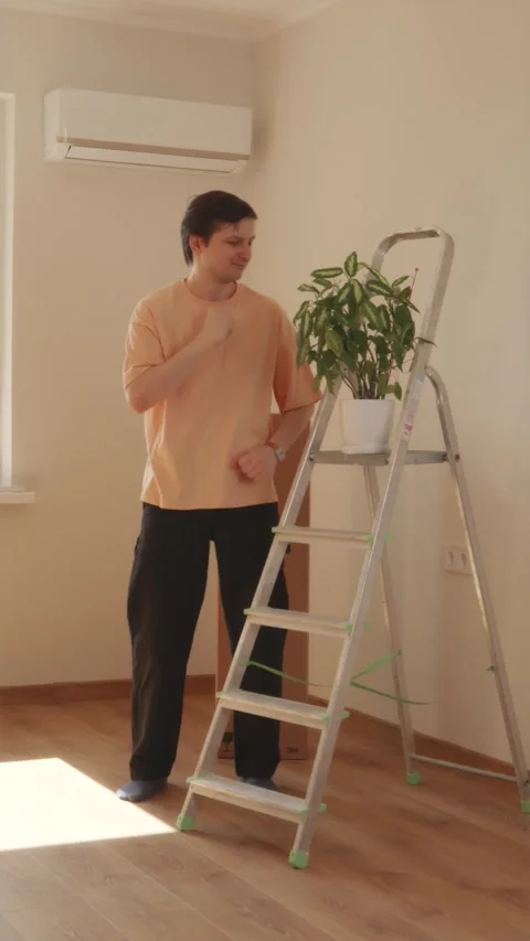 Man dancing with joy in empty sunlit apartment room Stock Footage 346396320