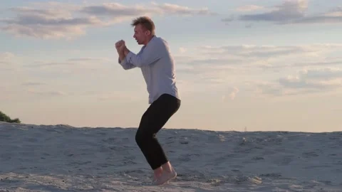 Man dancing modern ballet on the sand at sunset. Slow motion Stock Footage 135611600