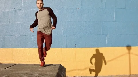 Man dancing in near the wall at dawn. 스톡 동영상 79737860