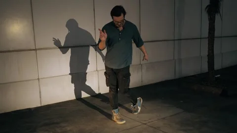 Man dancing at night in urban setting. Dancer on city street as freedom Stock Footage 303523666