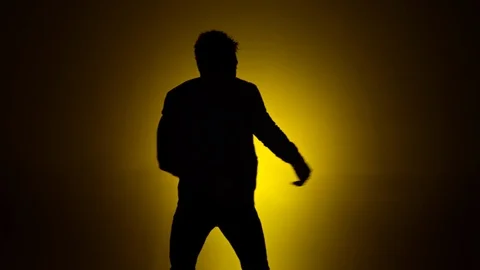Man dancing silhouette yellow background 1 Stock Footage 90794330