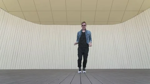 Man dancing street modern dance on an open stage in public park. Slow motion Stock Footage 132660040