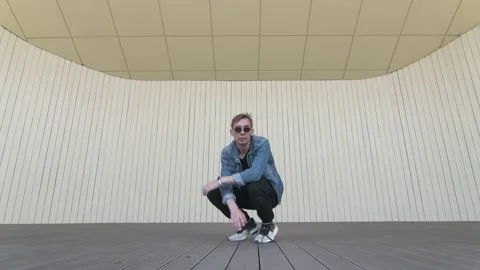 Man dancing street modern dance on an open stage in public park. Slow motion Stock Footage 132660064
