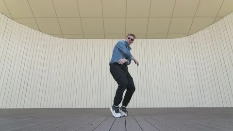 Man dancing street modern dance on an open stage in public park. Slow motion Stock Footage 132660090