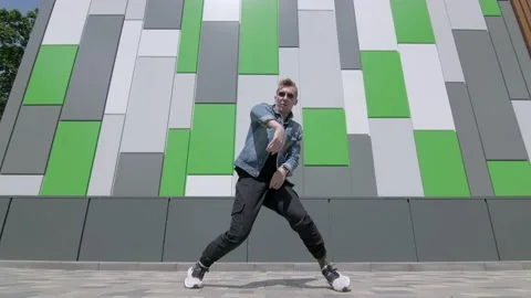Man dancing street modern dance on an open stage in public park. Slow motion Stock Footage 132660189
