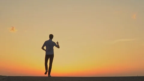 A man is dancing at sunset. slow motion Stock Footage 89383736