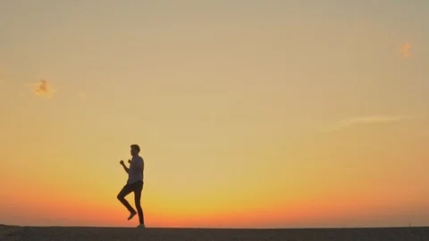 A man is dancing at sunset. slow motion Stock Footage 89383793