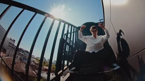 Man dancing on urban bridge with railings and buildings in background. confident Vídeos de archivo 345241147