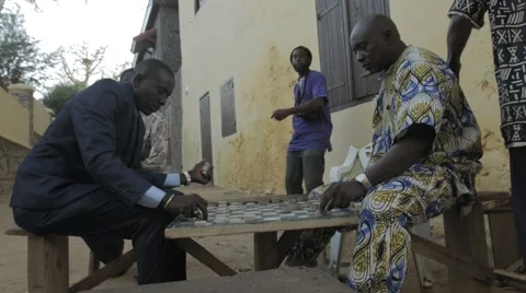 Man dancing while others play Checkerbord, Goree, Senegal Video stock 47946611