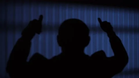 Man on a dark background raises his hands Stock Footage 146957854