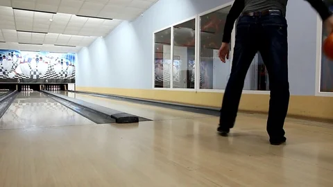 A man in dark clothes knocks down skittles and rejoices Video stock 111548572