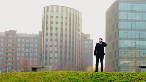 A man in a dark coat dials a number on the phone and speaks on the phone. Stock Footage 147140849