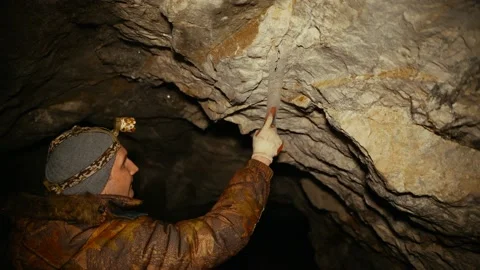 A man in the dark with a flashlight in the mine examines the traces of the drill Stock Footage 86076905