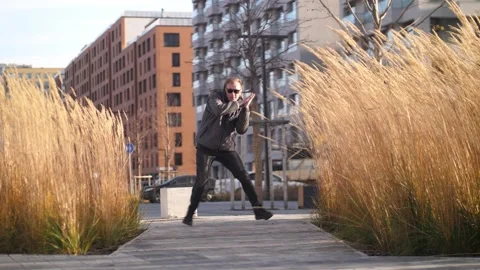 A man in dark glasses goes to the camera and dances a dance. Stock Footage 164914609