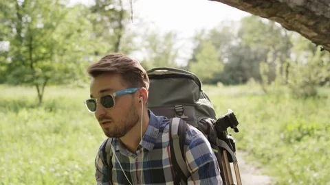Man With Dark Glasses Walking Under a Large Tree Branch Stock Footage 77671239