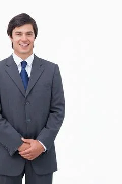 Man in dark gray suit standing left of center in studio wearing navy tie, copy Stock Photos