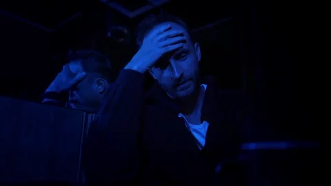 A man in a dark room with dim blue light tells some mystical story close-up Stock Footage 288146281