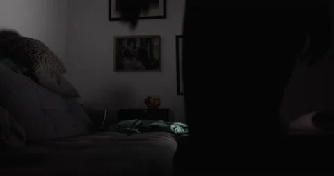 Man in a dark room sits on the sofa and looks at the screen of the laptop Stock Footage 130489641