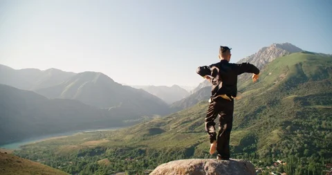 Man in dark uniform training martial arts forms alone for defense training and Stock Footage 116716920