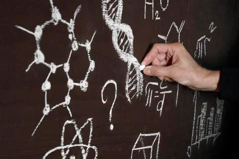 A man from darkness writes DNA code and formulas on a chalkboard. Stock Photos
