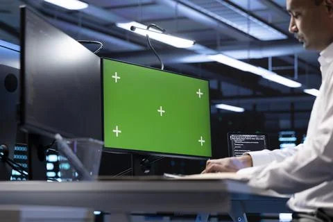 Man in data center using green screen computer to check server performance Foto stock