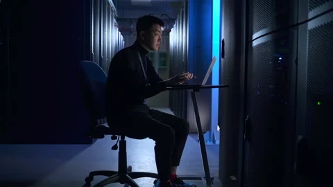 Man data engineer typing report on laptop keyboard and sitting at table in big Stock Footage 163816664