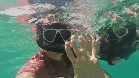 Man with daughter waving hands while snorkeling Vídeo Stock 234644109