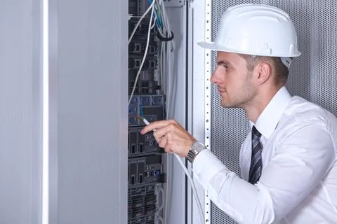 Man dealing with wires in a modern datacenter server room Stock Photos
