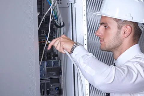 Man dealing with wires in a modern datacenter server room Stock Photos