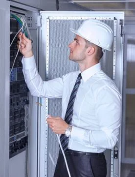 Man dealing with wires in a modern datacenter server room Stock Photos