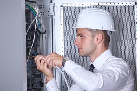 Man dealing with wires in a modern datacenter server room Stock Photos