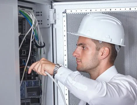 Man dealing with wires in a modern datacenter server room Stock Photos