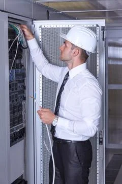 Man dealing with wires in a modern datacenter server room Stock Photos