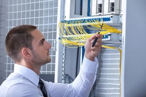 Man dealing with wires in a modern datacenter server room Stock Photos