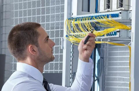Man dealing with wires in a modern datacenter server room Stock Photos