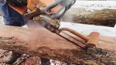 Man debarks a log with a chainsaw for woodworking project Stock Footage 321797253
