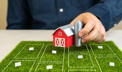 A man decides which plot of land to buy for a farm. Soil quality, location, c Stock Photos