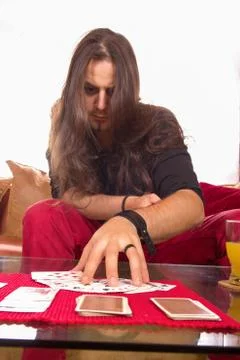 Man with a deck of cards on the table in game Stock Photos