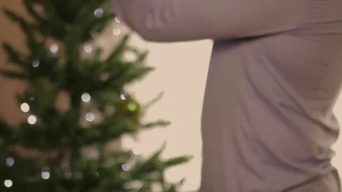 Man decorates Christmas Tree bokeh view Stock Footage 80991348