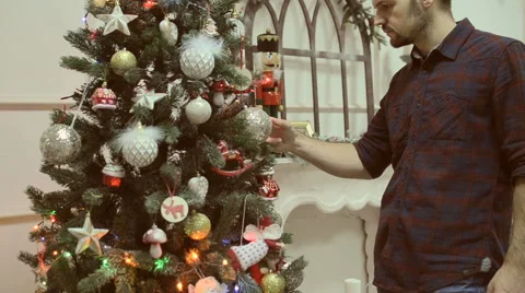 Man decorates a Christmas tree at home Video stock 58620185