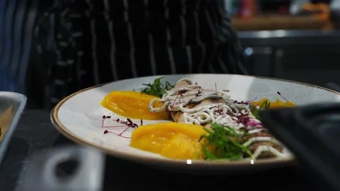 A man decorates a dish with microgreens before serving in a restaurant kitchen Stock Footage 141100978