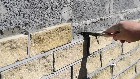 Man decorates the facade of a wall with decorative bricks, close up view. Stock Footage 153927645